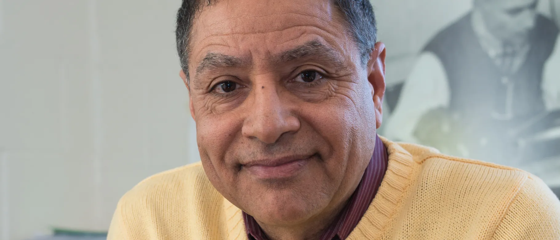 Portrait of man in yellow sweater smiling at camera