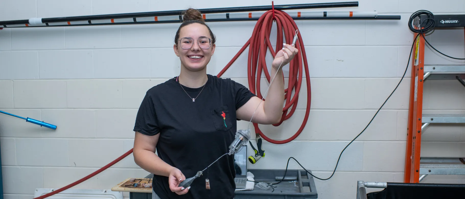 Image of student Bethany Brodbeck smiling at camera holding device to repel sharks from bait