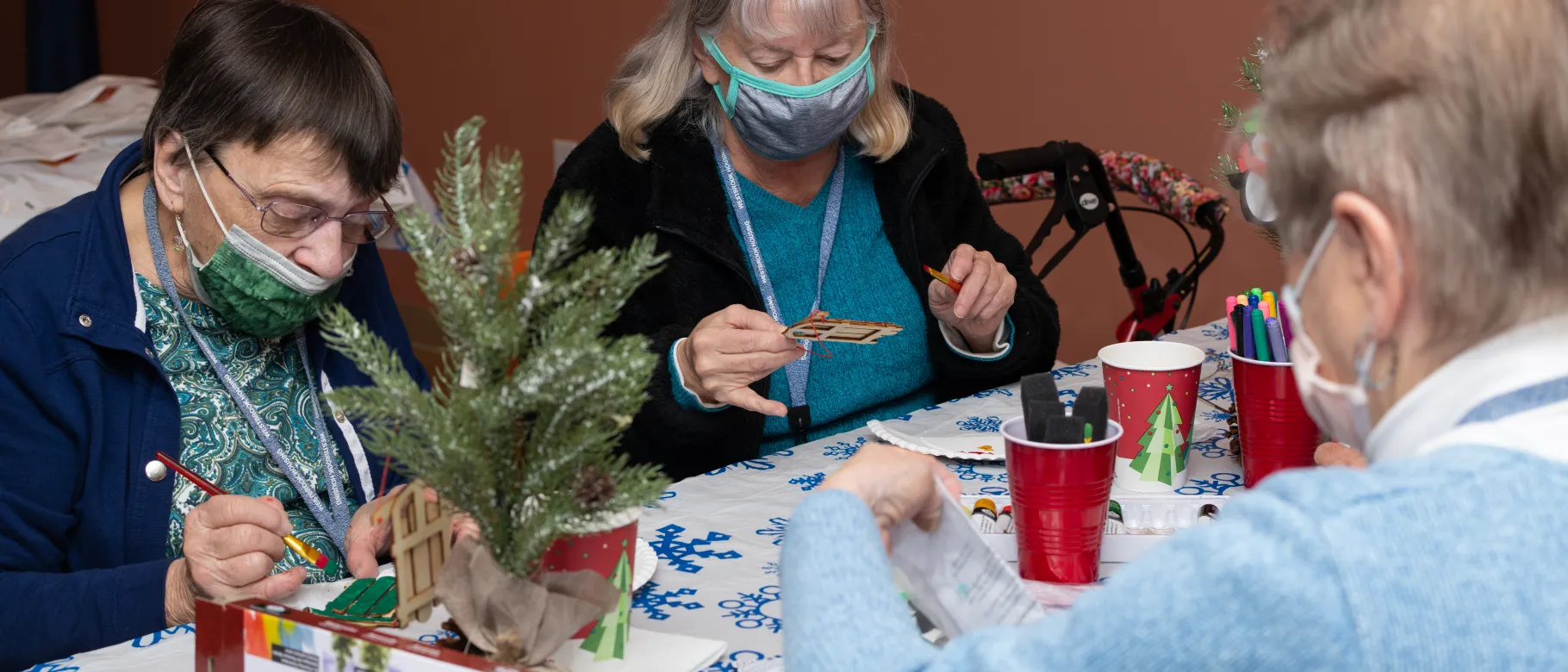 People paint holiday-themed crafts at a wellness fair for Westbrook Housing residents