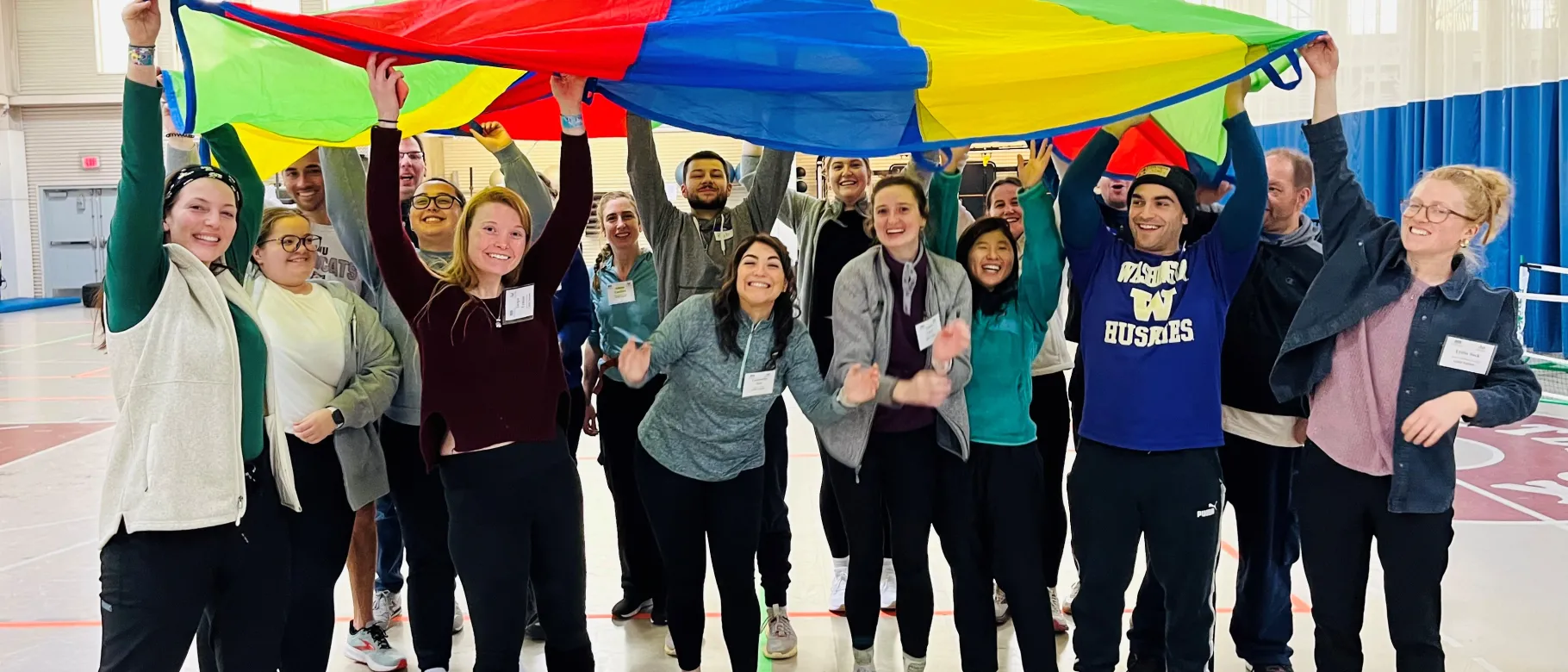 students holding up colorful parachute