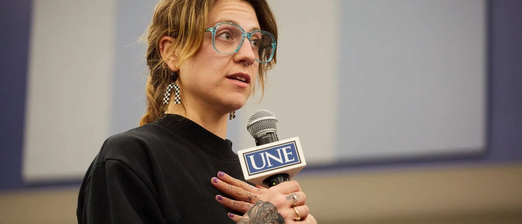 A student asks a question through a microphone in a lecture hall