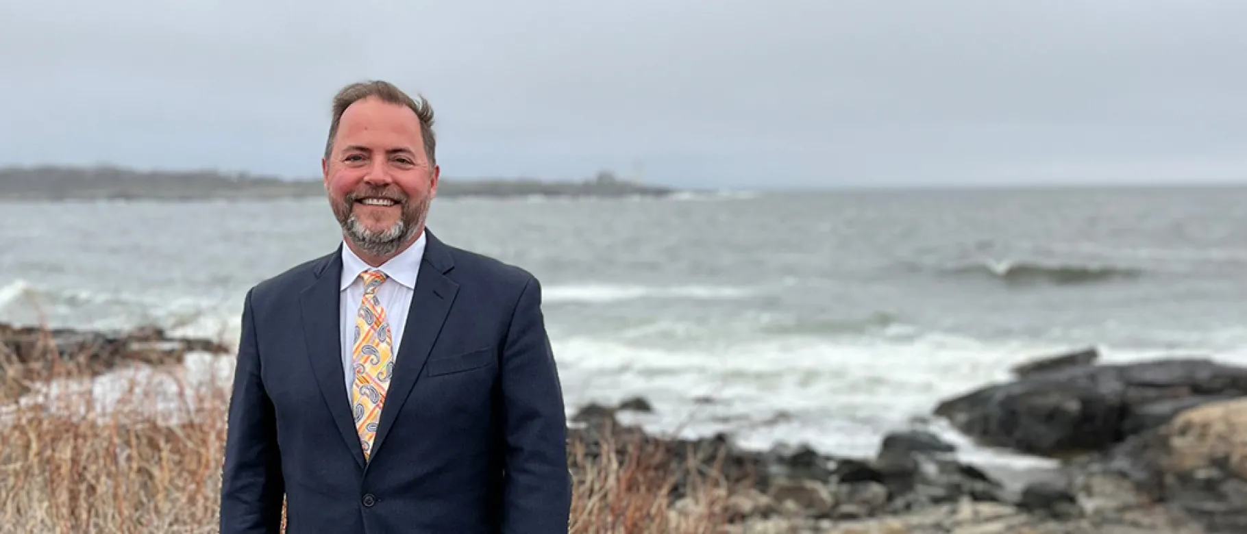 Portrait of Jim Irwin smiling with the ocean in the background