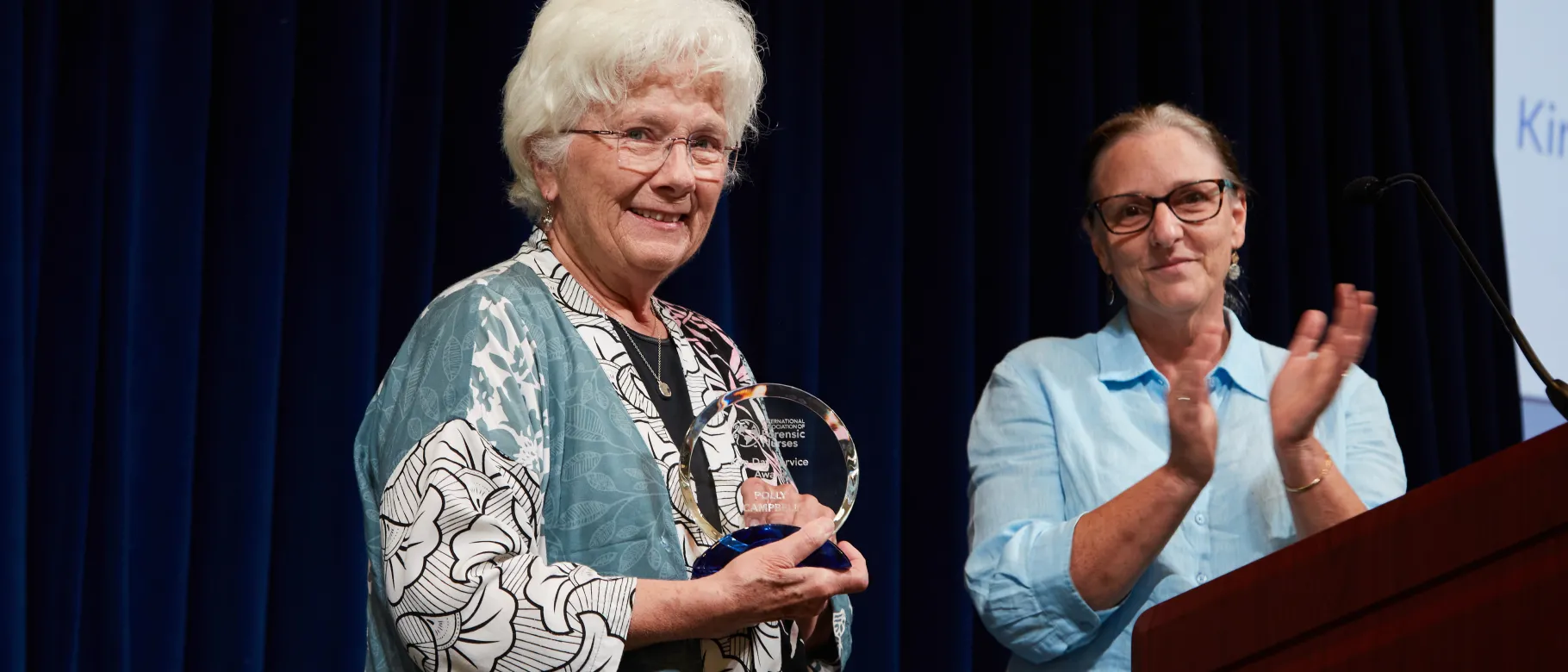 UNE's Polly Campbell holds an award presented to her by Mary Ann Ordelt