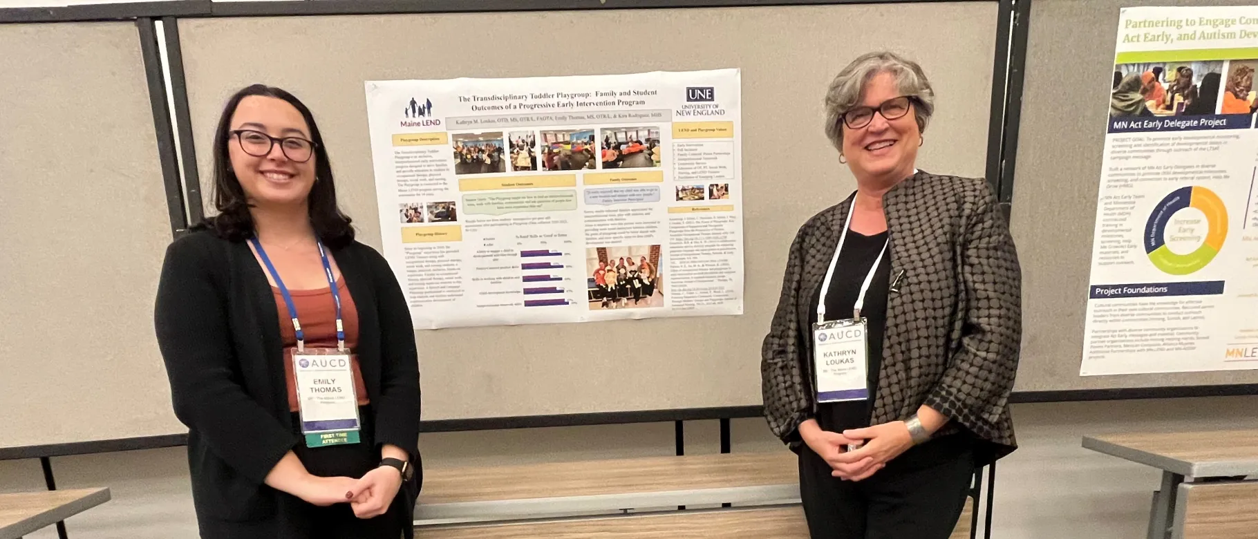 Photo of Emily Thomas and Kathryn Loukas posing in front of a research poster