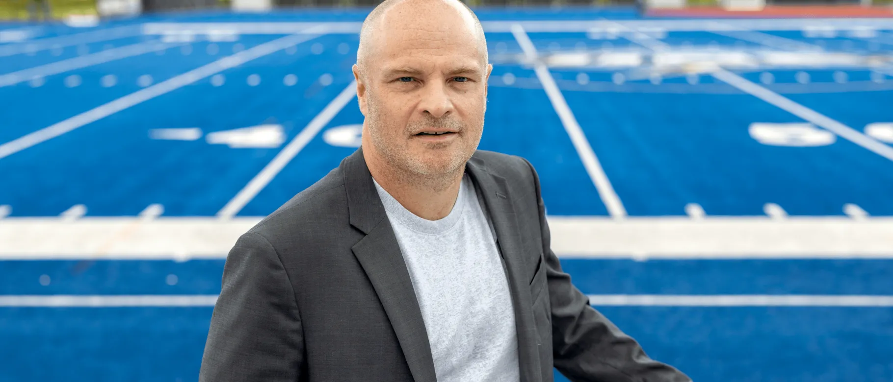 Portrait of Norm O'Reilly with the UNE football field in the background