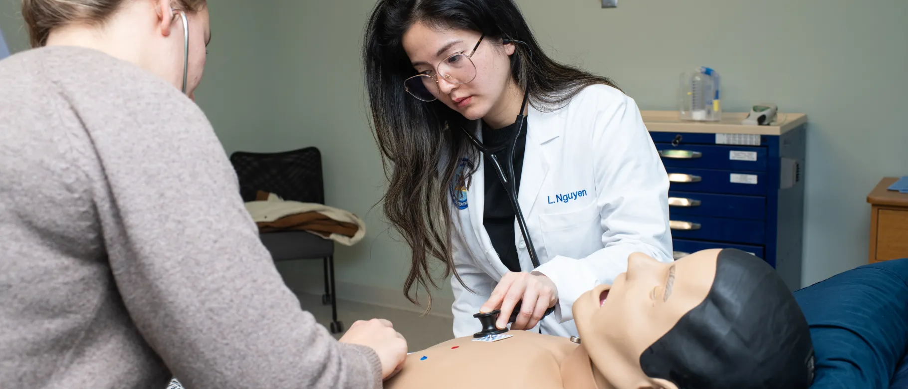 A medical student and PA student listen to the heartbeat of a high-fidelity patient simulation mannequin