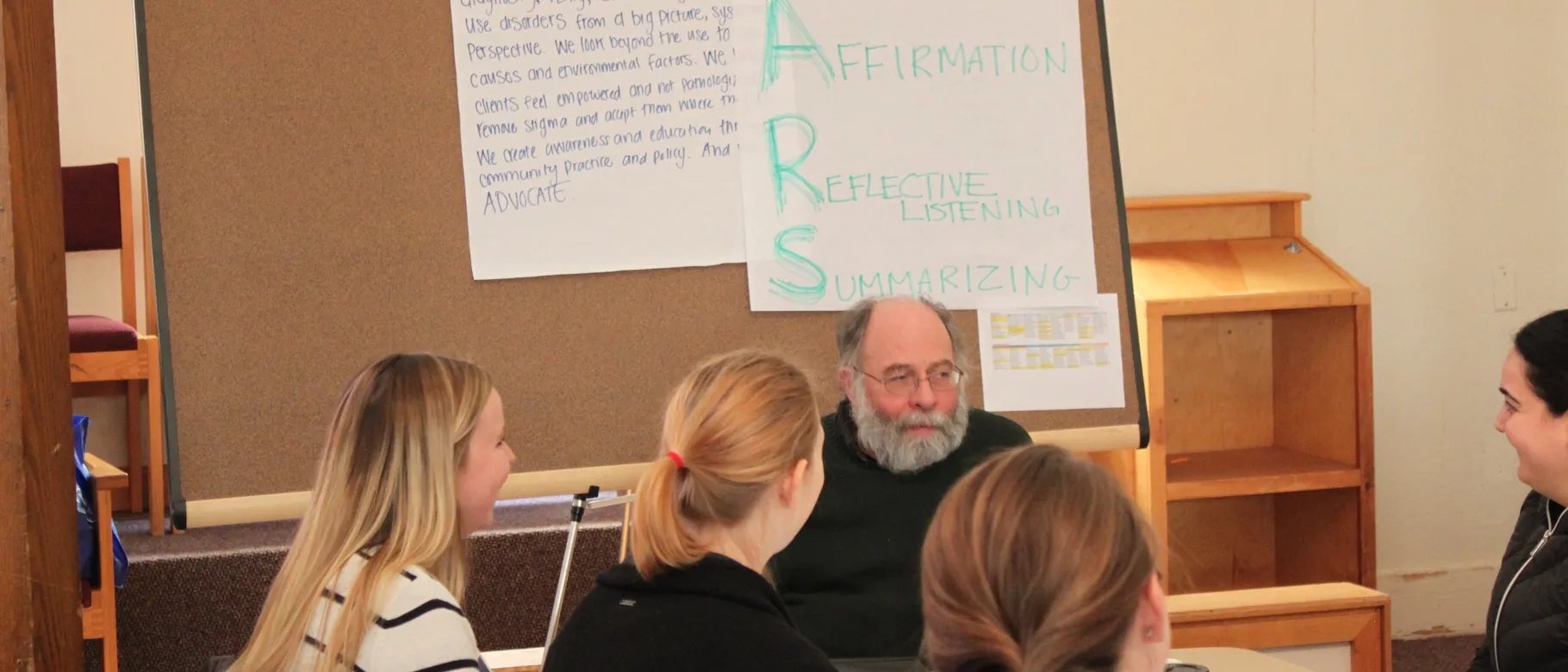 UNE health professions students talk with actor Bob Pettee, who plays the role of a patient during SBIRT training