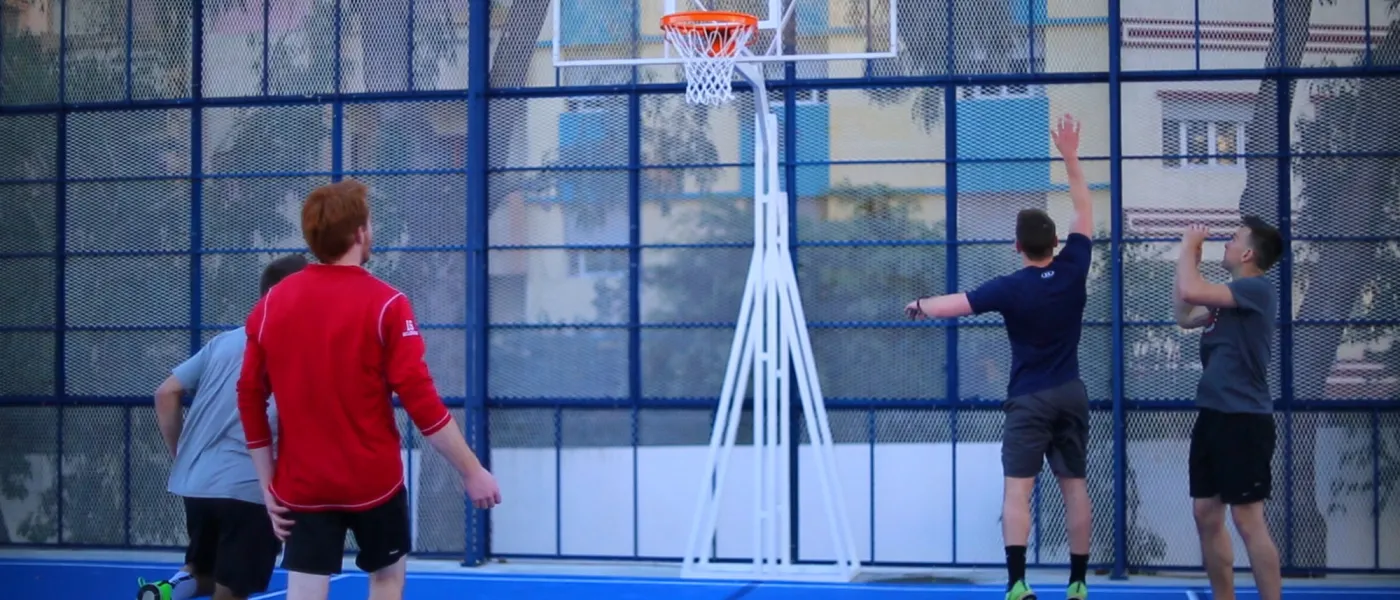 Students play basketball on the basketball and volleyball court at U N E Tangier