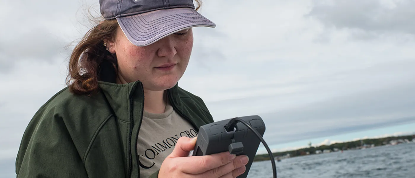 A U N E student uses a water temperature tool