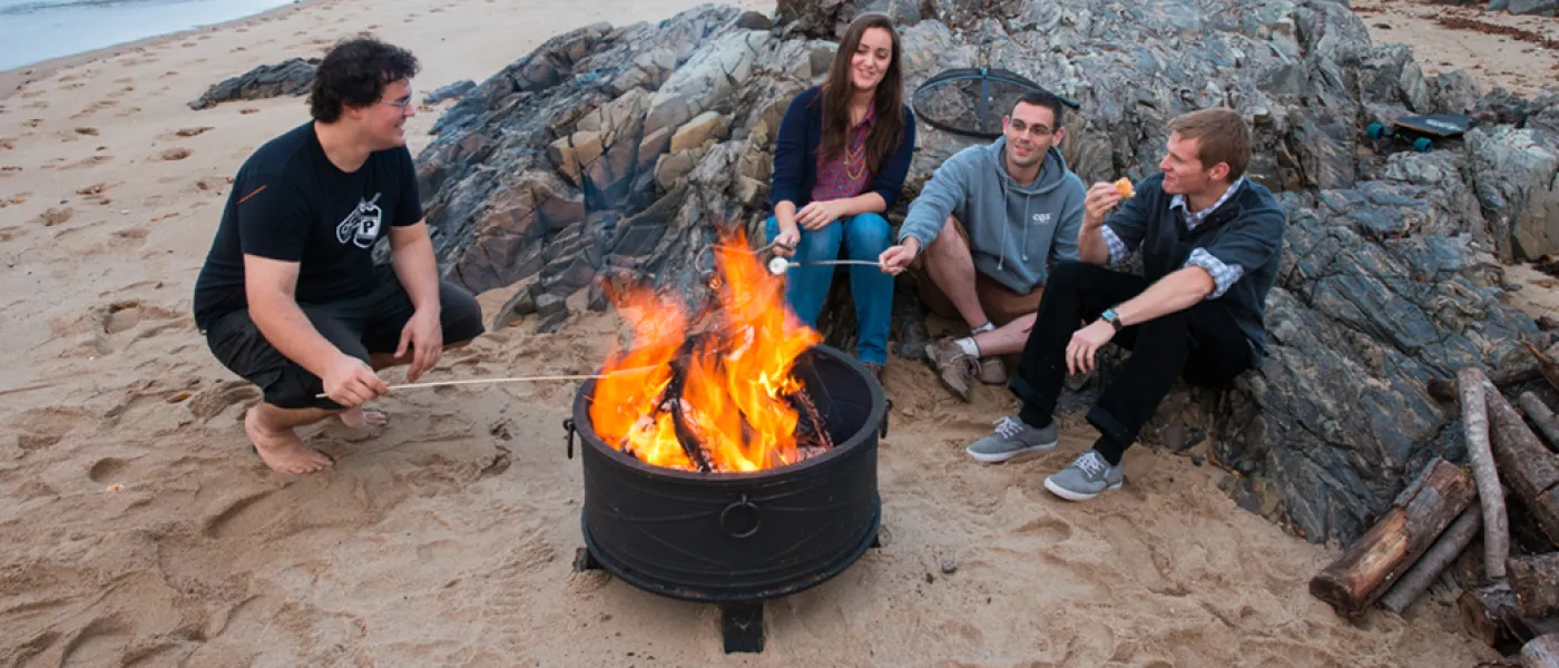 Students at a bonfire on the beach