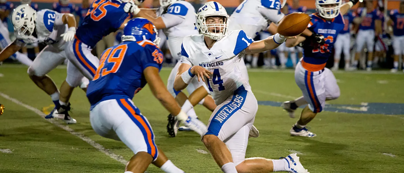 U N E football player catching the ball during a game