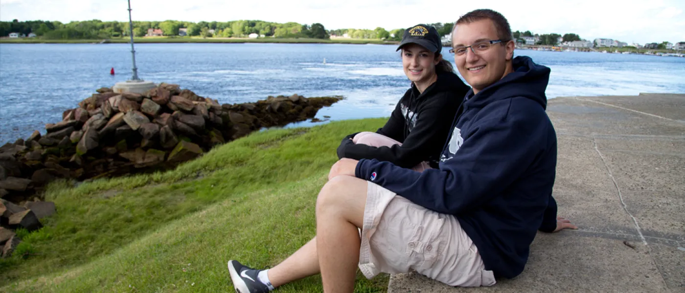 Two students sitting together on Jordan Point in front of the water