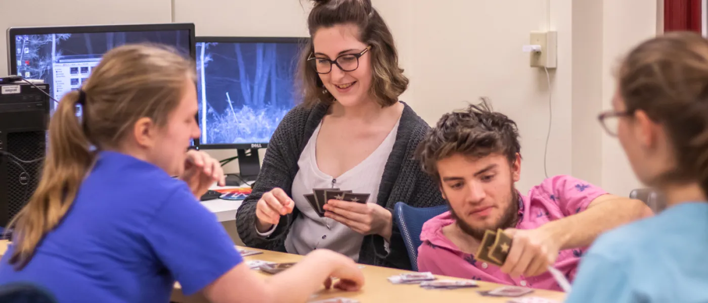 Four students playing a card game