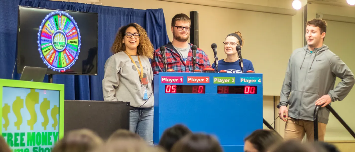 Four students on stage leading a game night