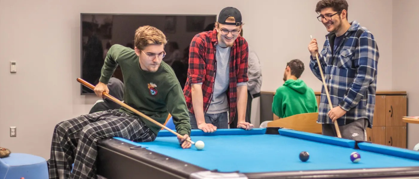 Three students playing pool