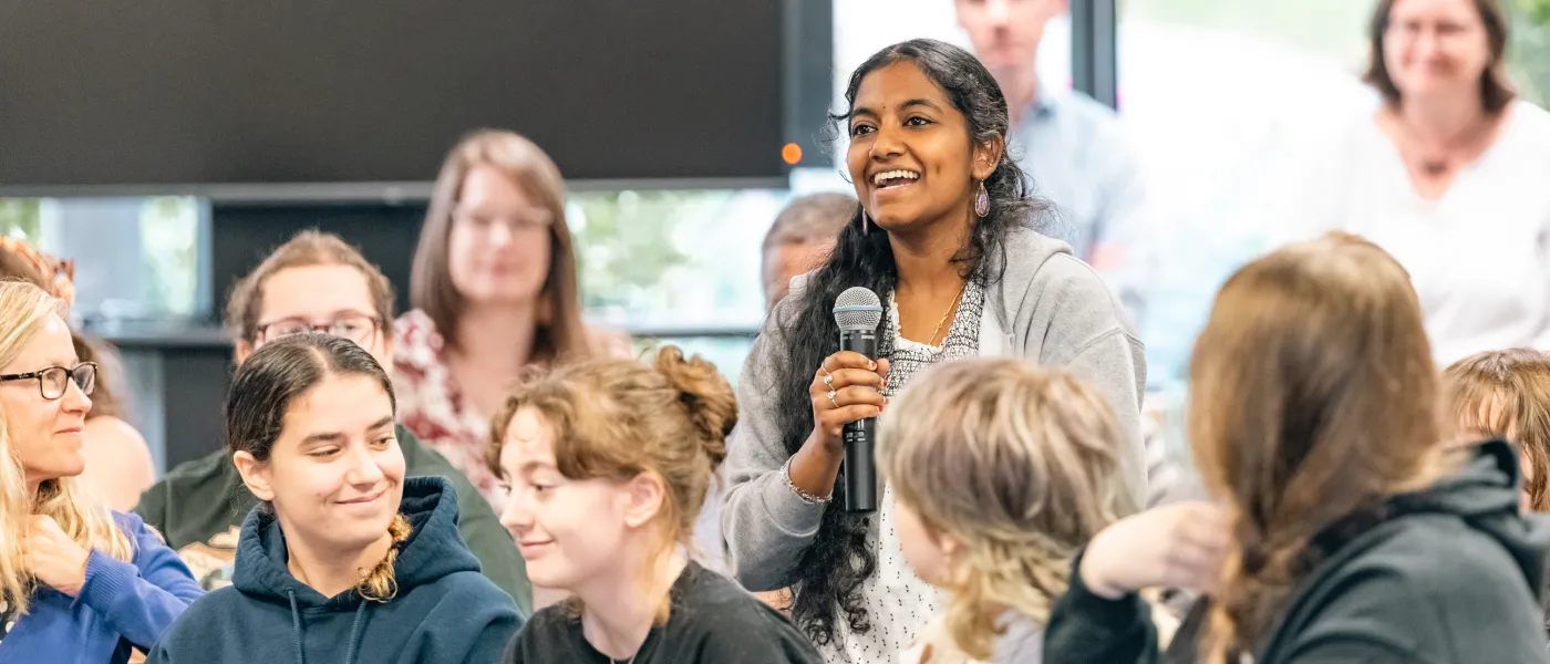 A student stands to ask Talty a question