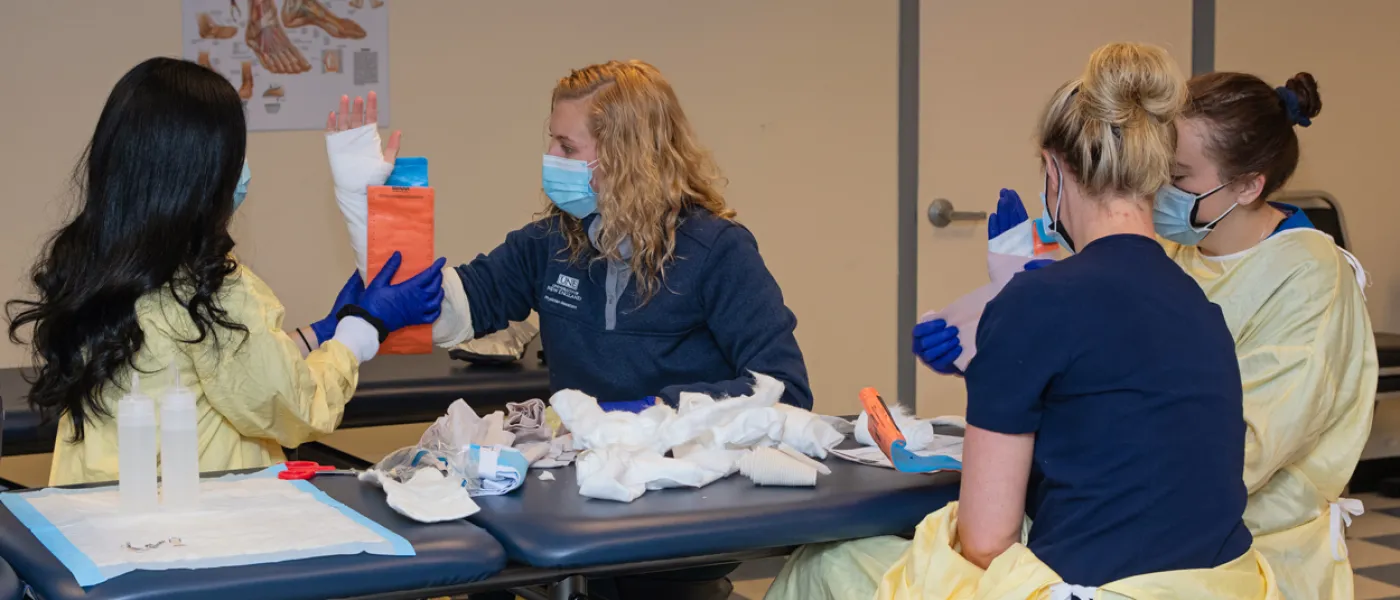 A group of P A students practice placing casts on each other's arms