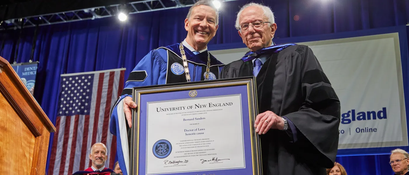 President James D. Herbert hands Sen. Bernie Sanders his honorary degree at 2024 University of New England commencement