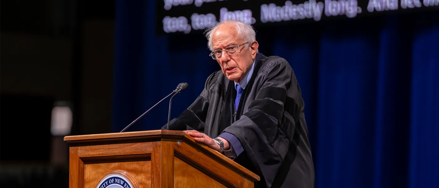 U.S. Senator Bernie Sanders stands at podium at U N E's 2024 graduation ceremony