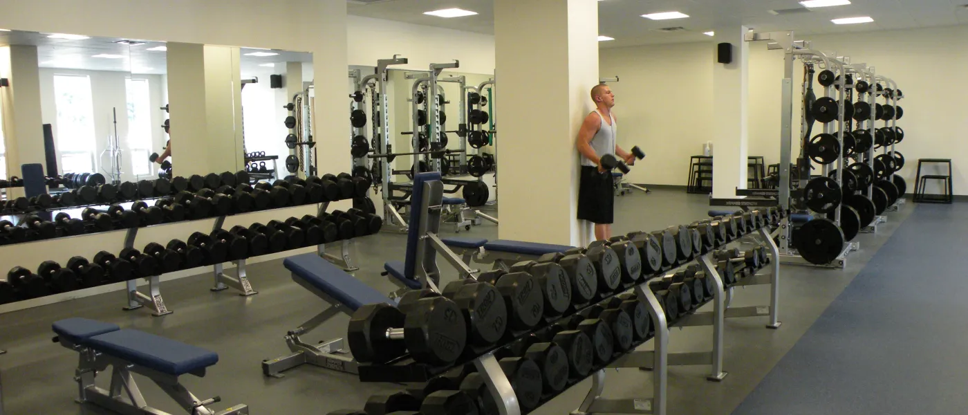 A student uses the weight room on the U N E campus