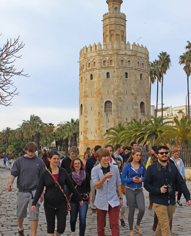 A group of students walk past a Spanish tower