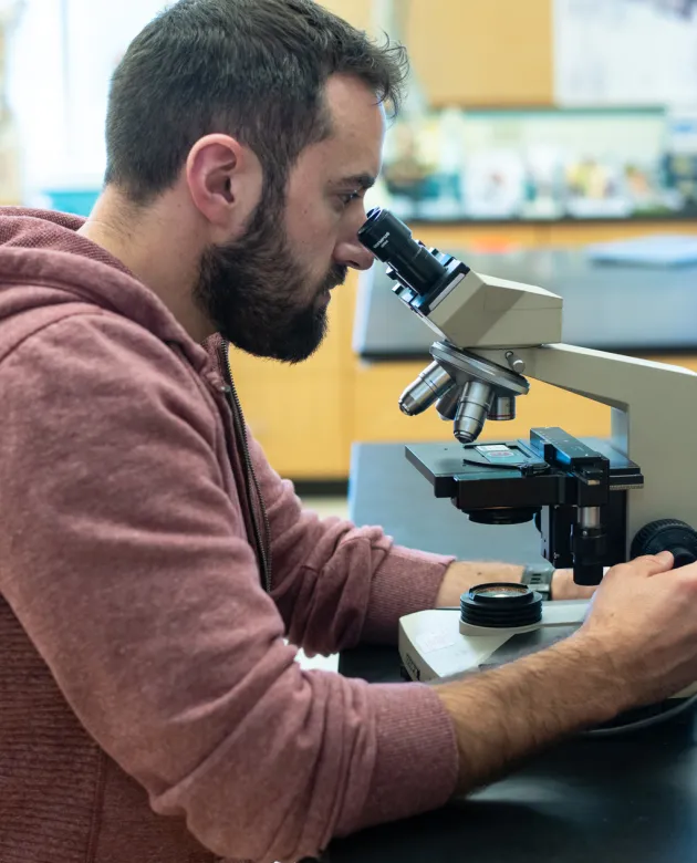 A student peers into a microscope