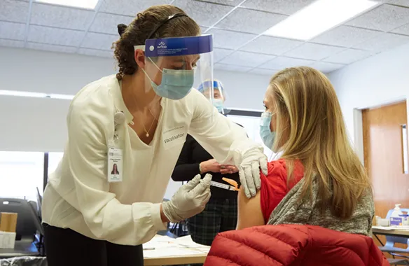 A U N E health professions student vaccinating a patient