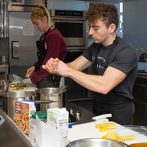 A nutrition student squeezes lemon juice into a pot