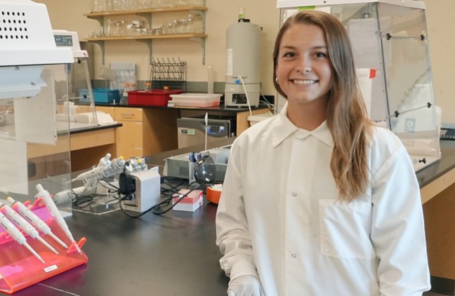 Avery Bond in a whitecoat standing in a lab