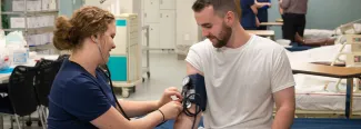 U N E nursing students practicing obtaining the blood pressure