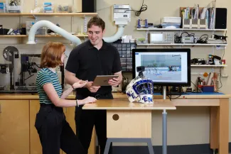 Students in makerspace with goal-training device