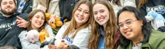 A row of students sitting in the stands at a U N E hockey game