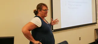 teacher standing in front of screen teaching