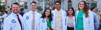 Six University of New England medical school students pose in their white coats