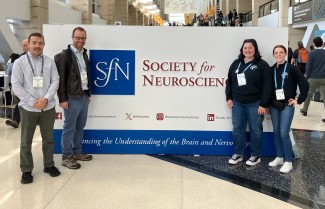 A group of UNE researchers pose in front the Society for Neuroscience sign