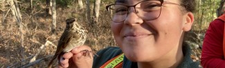 Haley Hines holds a wild bird that Professor Noah Perlut's class will band. 