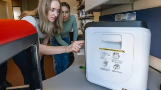 Two students operate a 3D printer