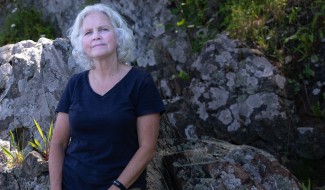 UNE's Pam Morgan poses against a rocky outcropping