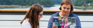 Two U N E students study on the waterfront of the Biddeford campus