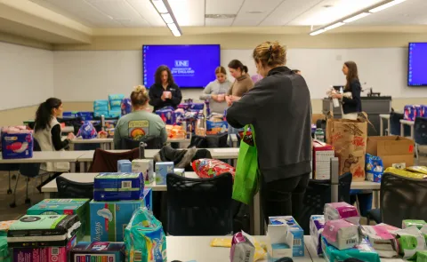 students filling kits full of reproductive health supplies