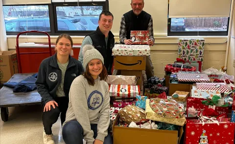 Members of UNE's Pediatrics Club and Sigma Sigma Phi pose with a variety of wrapped presents they plan to donate