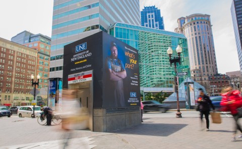 A UNE advertisement adorns a subway entrance in downtown Boston, Mass.