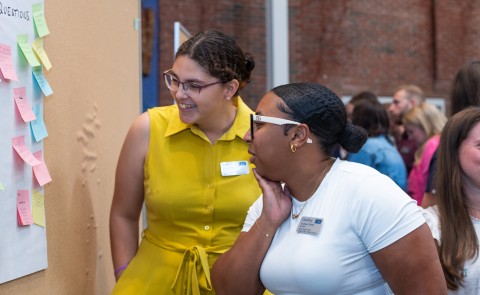 two students engage with questions on sticky notes