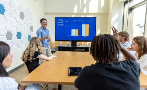 person lectures in front of students in college of business