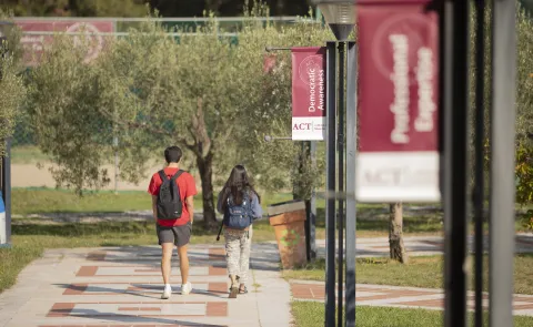 Students walk along a path at the American College of Thessaloniki in Greece