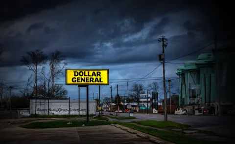 A Dollar General sign is illuminated against a dark sky