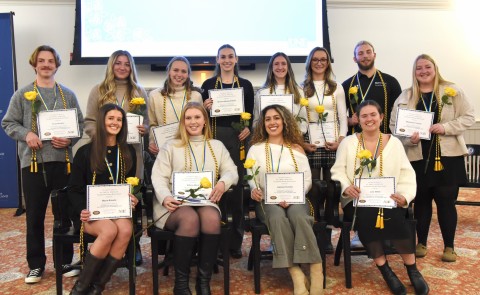 A group of occupational therapy students poses wearing their honor cords