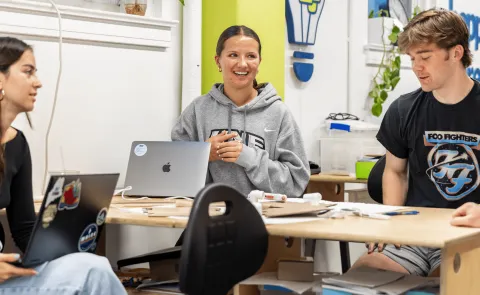 Three UNE students work around a table in the Makerspace