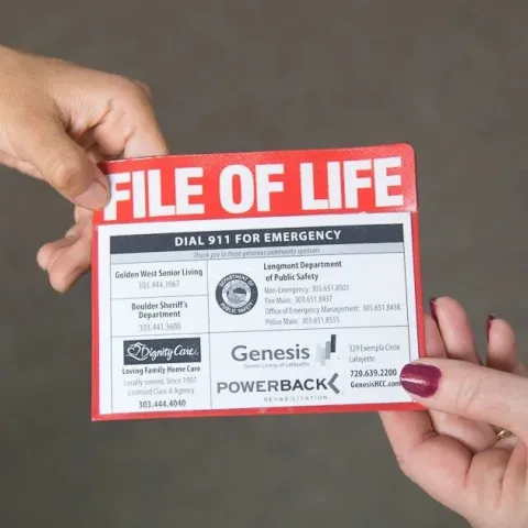 The File of Life pamphlet is shown being handed between two people