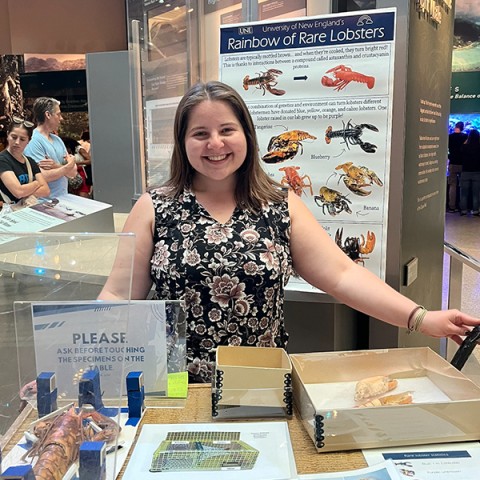 A UNE researcher poses for a photo with her research materials at the Smithsonian natural history museum